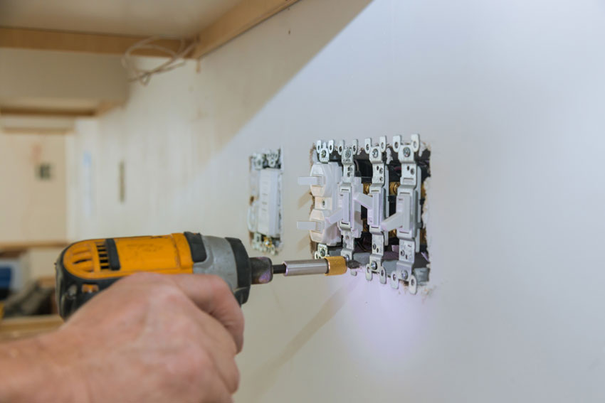 electrician changes outlets and switches