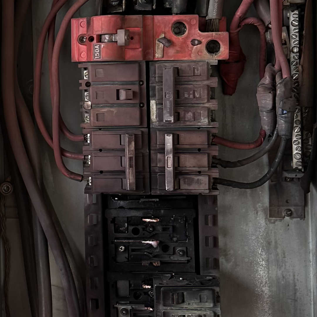 Fire-damaged electrical panel with aluminum branch circuit wiring showing overheated connections, scorched breaker components, and signs of electrical arcing, illustrating the safety risks of aging aluminum wiring systems in older Maricopa County, Arizona homes.